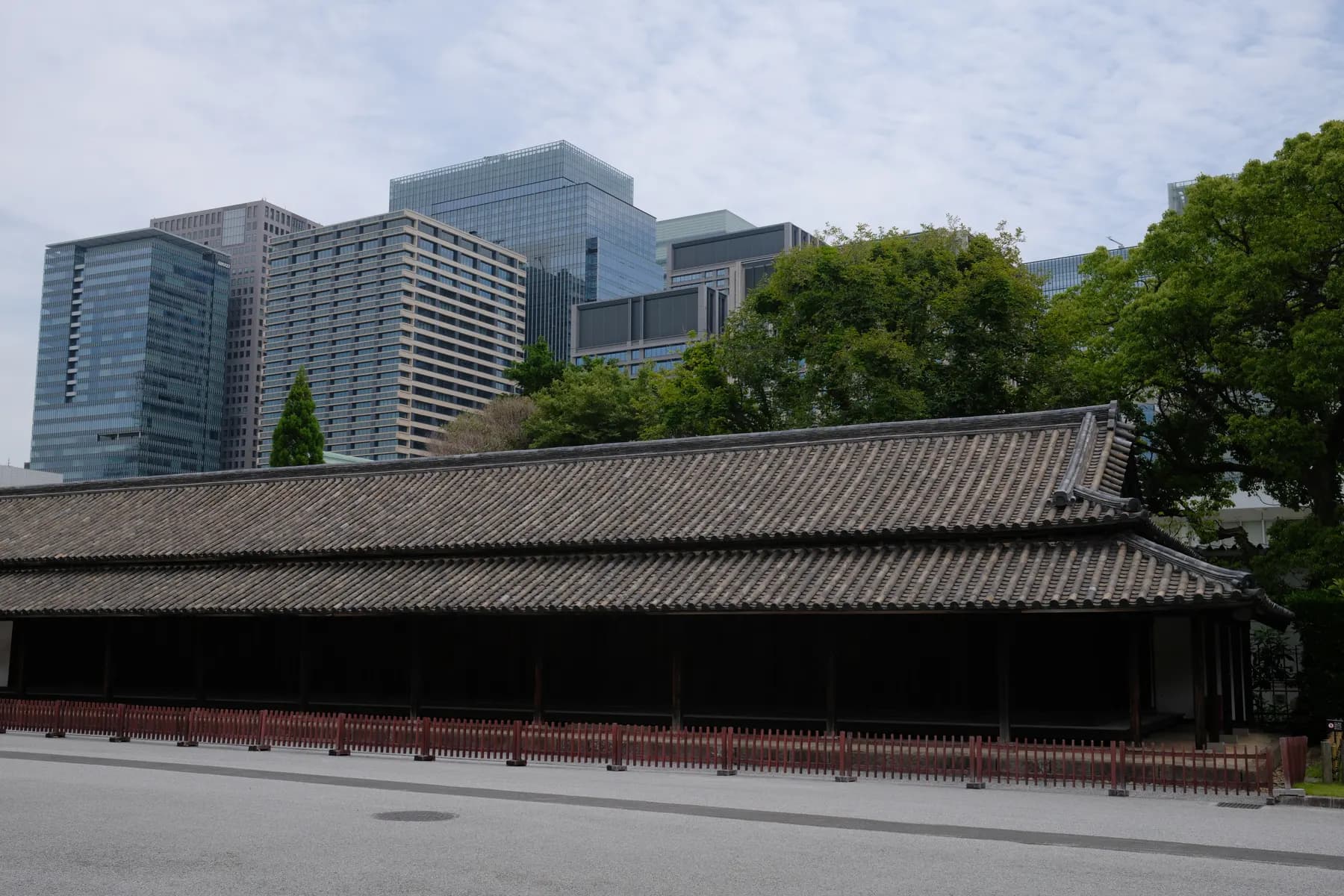 A traditional Japanese building contrasts with modern skyscrapers in the background