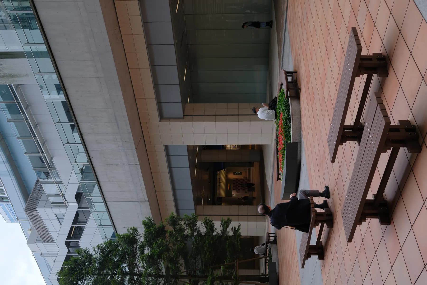 A serene urban courtyard with people relaxing and interacting in a modern architectural setting