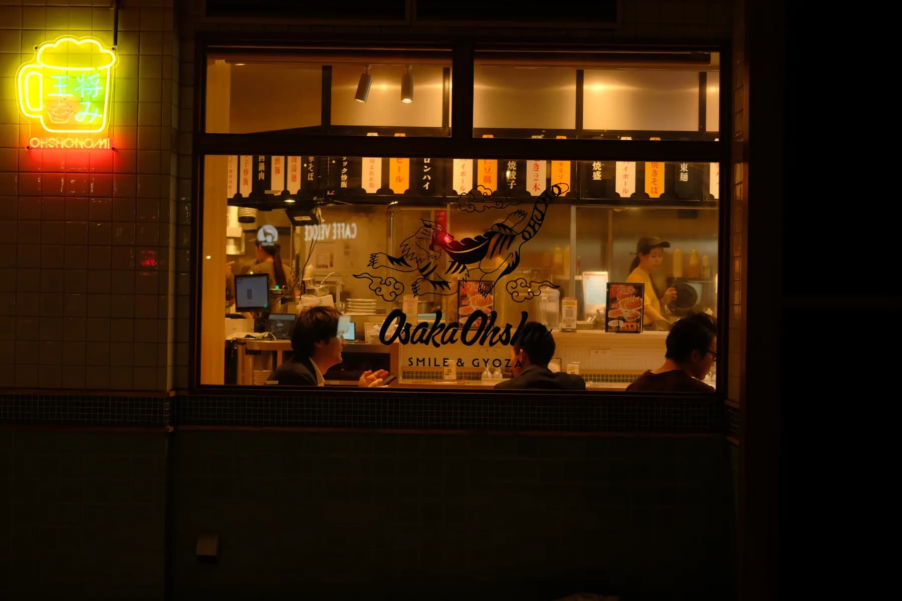 A cozy night scene at a restaurant with people eating and working