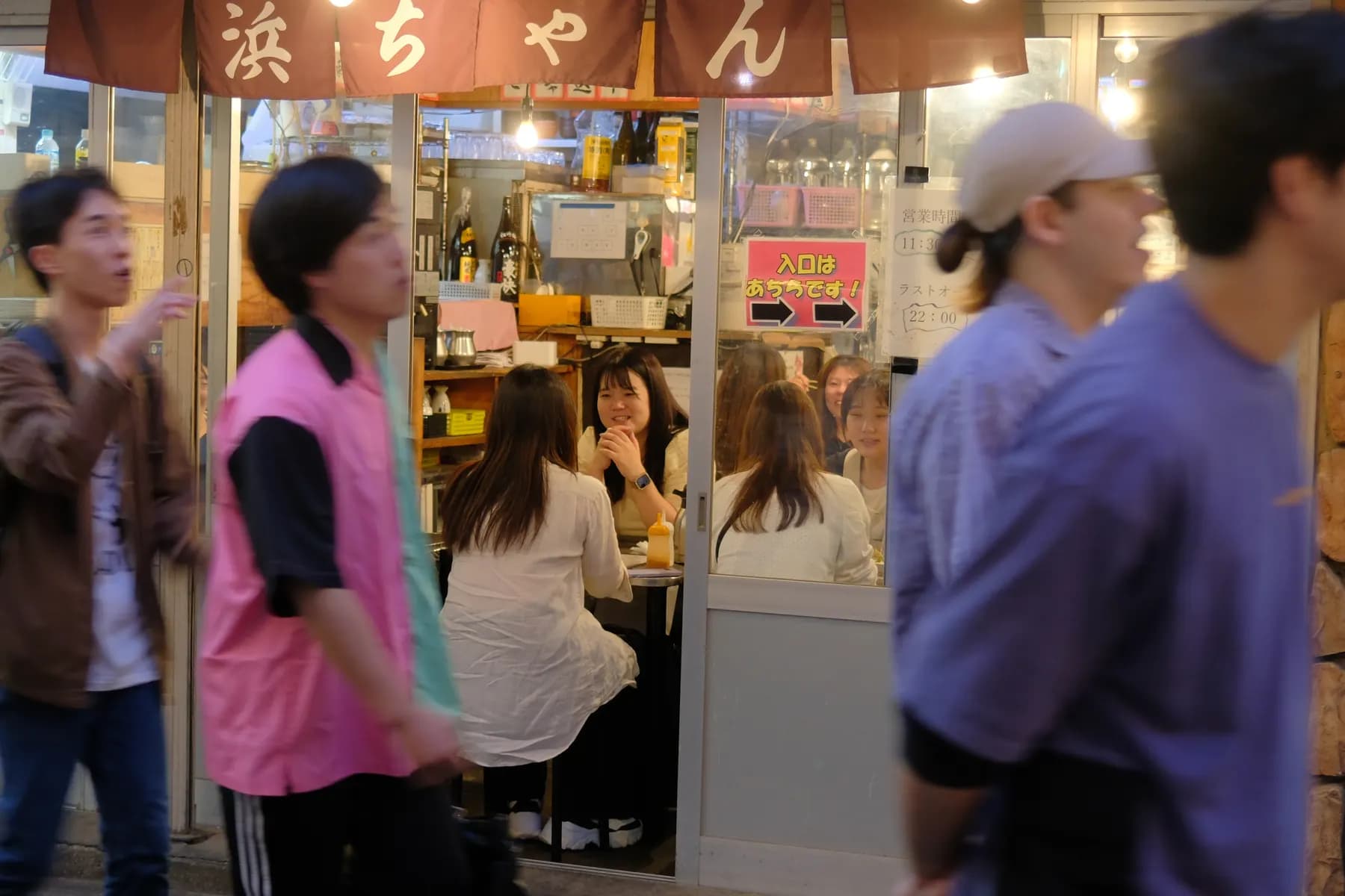 A bustling street scene at a small restaurant with people interacting and waiting