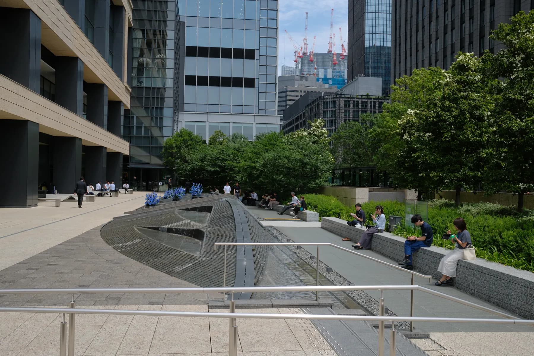 A modern urban park with people relaxing and walking